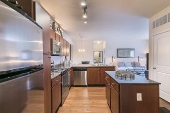 A modern kitchen with stainless steel appliances and wooden cabinets.